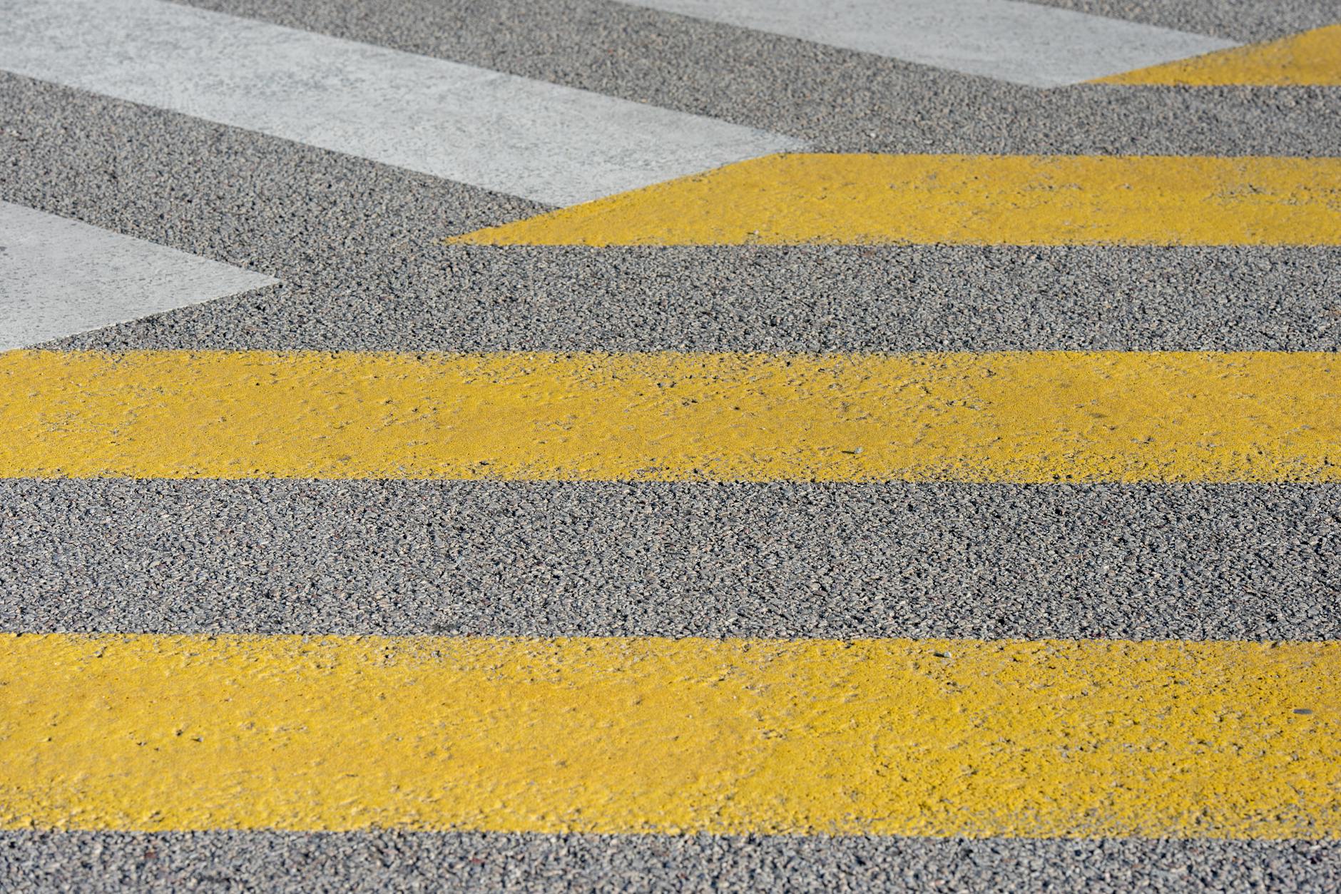 Skośne pasy przejścia dla pieszych z białymi i żółtymi liniami