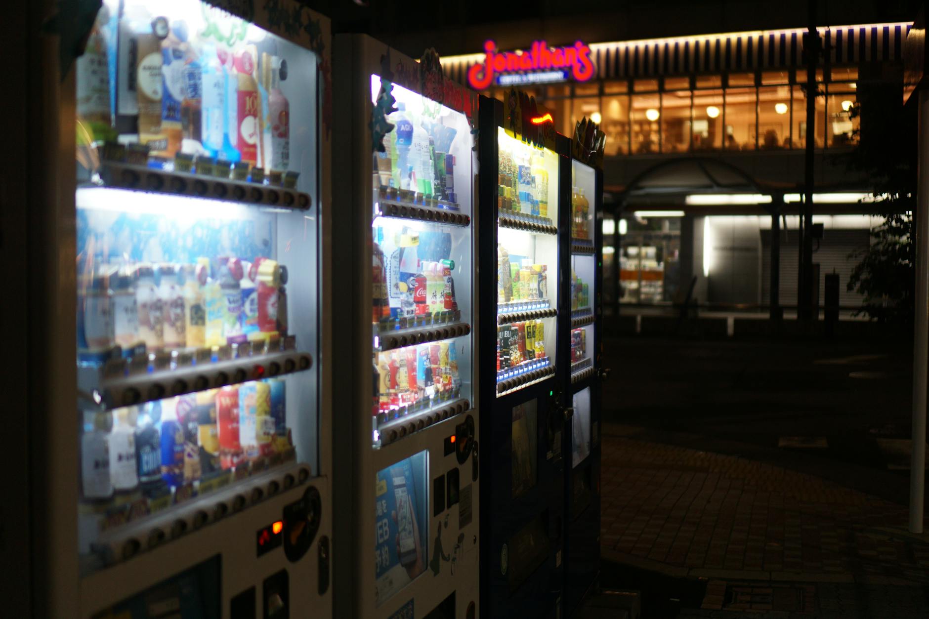 Podświetlone automaty sprzedające na nocnej ulicy Tokio
