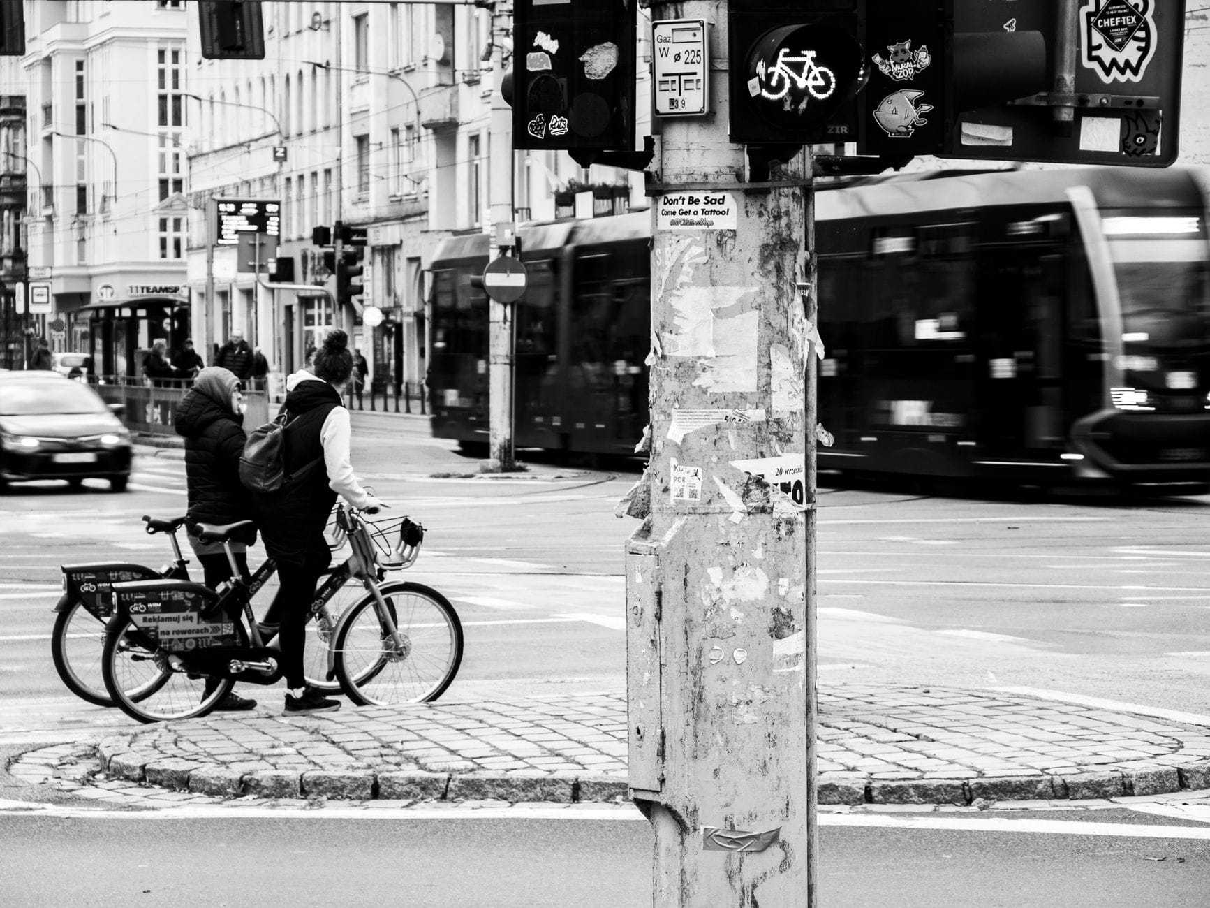 Dwóch rowerzystów czeka na światłach na ruchliwym skrzyżowaniu